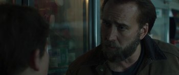Movie still from “Joe” (2013), directed by David Gordon Green – A man with a goatee looking out of a window; Close Up shot, Over the shoulder angle