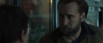Movie still from “Joe” (2013), directed by David Gordon Green – A man with a goatee looking out of a window; Close Up shot, Over the shoulder angle