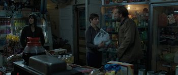 Movie still from “Joe” (2013), directed by David Gordon Green – A man and a woman standing next to each other in front of a refrigerator; Medium shot, Over the shoulder angle