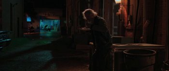 Movie still from “Joe” (2013), directed by David Gordon Green – An old man eating a piece of pizza in the dark; Wide shot, Over the shoulder angle