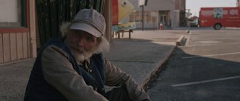 Movie still from “Joe” (2013), directed by David Gordon Green – An old man sitting on the side of the street; Medium shot, Over the shoulder angle