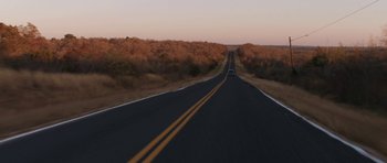 Movie still from “Joe” (2013), directed by David Gordon Green – A car driving down the middle of a road; Extreme Wide shot, High angle