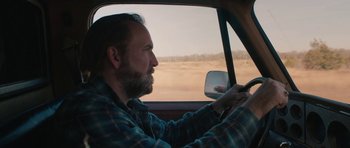 Movie still from “Joe” (2013), directed by David Gordon Green – A man driving a car in the middle of the desert; Close Up shot, Over the shoulder angle