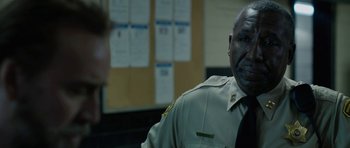 Movie still from “Joe” (2013), directed by David Gordon Green – A man in a police uniform talking to another man; Close Up shot, Over the shoulder angle