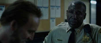 Movie still from “Joe” (2013), directed by David Gordon Green – A police officer in uniform is talking to a man; Close Up shot, Over the shoulder angle