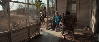 Movie still from “Joe” (2013), directed by David Gordon Green – Two people sitting on a porch looking out a window; Wide shot, Low angle
