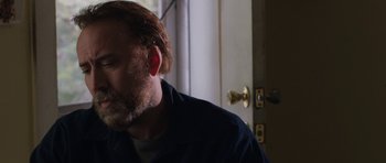 Movie still from “Joe” (2013), directed by David Gordon Green – A person wearing a blue shirt near a white door; Close Up shot, Over the shoulder angle