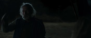 Movie still from “Joe” (2013), directed by David Gordon Green – A man with long white hair is standing in the dark; Close Up shot, Over the shoulder angle