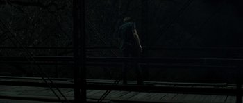Movie still from “Joe” (2013), directed by David Gordon Green – A man walking across a bridge in the dark; Wide shot, Low angle