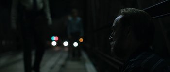 Movie still from “Joe” (2013), directed by David Gordon Green – A man with a long beard standing next to a train; Close Up shot, Over the shoulder angle