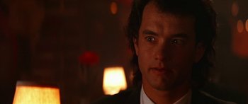 Movie still from “Joe Versus the Volcano” (1990), directed by John Patrick Shanley – A person wearing a suit and tie; Close Up shot, Over the shoulder angle