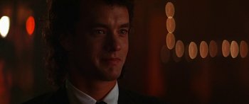 Movie still from “Joe Versus the Volcano” (1990), directed by John Patrick Shanley – A person wearing a suit and tie; Close Up shot, Over the shoulder angle