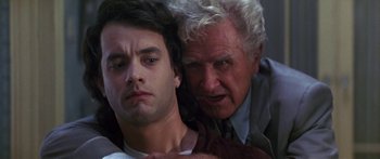 Movie still from “Joe Versus the Volcano” (1990), directed by John Patrick Shanley – A man and a woman are hugging and looking at the camera; Close Up shot, Low angle