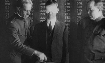 Movie still from “Johnny Got His Gun” (1971), directed by Dalton Trumbo – A man in a suit standing next to another man in a suit; Medium shot, Over the shoulder angle