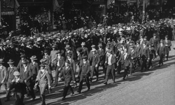 Movie still from “Johnny Got His Gun” (1971), directed by Dalton Trumbo – A black and white photo of a crowd of men in suits; Extreme Wide shot, High angle