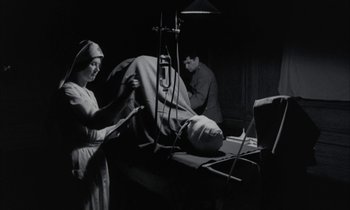 Movie still from “Johnny Got His Gun” (1971), directed by Dalton Trumbo – An old photo of a woman working in a room; Medium shot, Low angle