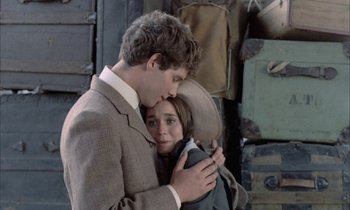 Movie still from “Johnny Got His Gun” (1971), directed by Dalton Trumbo – A man and a woman embracing each other in front of a pile of suitcases; Close Up shot, Over the shoulder angle