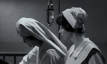 Movie still from “Johnny Got His Gun” (1971), directed by Dalton Trumbo – Two women in a room with a microphone in the background; Medium shot, Low angle