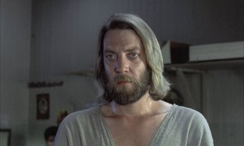 Movie still from “Johnny Got His Gun” (1971), directed by Dalton Trumbo – A man with long hair and a beard stares at the camera; Close Up shot, Low angle