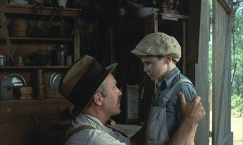 Movie still from “Johnny Got His Gun” (1971), directed by Dalton Trumbo – An older man and a young boy are talking; Medium shot, Over the shoulder angle