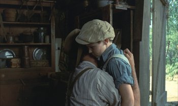 Movie still from “Johnny Got His Gun” (1971), directed by Dalton Trumbo – A man and a woman hugging in a room; Medium shot, Over the shoulder angle