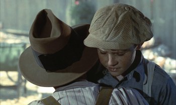 Movie still from “Johnny Got His Gun” (1971), directed by Dalton Trumbo – A young boy wearing a hat and a tie; Close Up shot, Over the shoulder angle