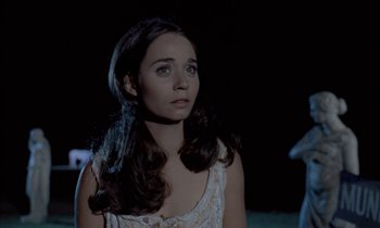 Movie still from “Johnny Got His Gun” (1971), directed by Dalton Trumbo – A woman with long dark brown hair standing in a field at night; Close Up shot, Over the shoulder angle