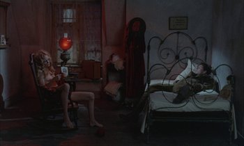 Movie still from “Johnny Got His Gun” (1971), directed by Dalton Trumbo – A woman sitting on a chair next to a bed; Wide shot, High angle