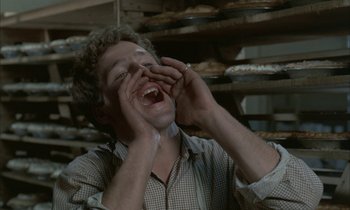 Movie still from “Johnny Got His Gun” (1971), directed by Dalton Trumbo – A man is laughing while holding his hands up to his face; Close Up shot, High angle
