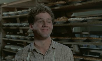 Movie still from “Johnny Got His Gun” (1971), directed by Dalton Trumbo – A man standing in front of pans of food; Close Up shot, Over the shoulder angle