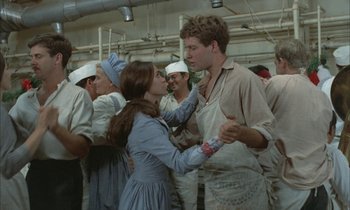 Movie still from “Johnny Got His Gun” (1971), directed by Dalton Trumbo – A man and a woman are dancing in a kitchen; Medium shot, Over the shoulder angle