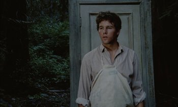 Movie still from “Johnny Got His Gun” (1971), directed by Dalton Trumbo – A man standing in front of an old door; Medium shot, Low angle