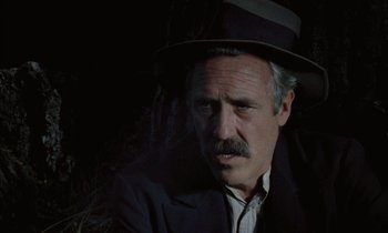 Movie still from “Johnny Got His Gun” (1971), directed by Dalton Trumbo – A man with a mustache wearing a hat and a suit; Close Up shot, Low angle