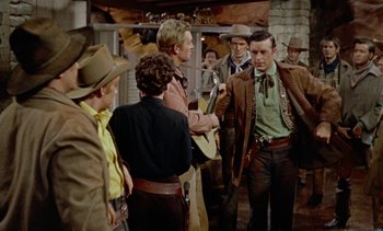 Movie still from “Johnny Guitar” (1954), directed by Nicholas Ray – A group of people standing around a building; Medium shot, Over the shoulder angle