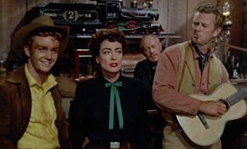 Movie still from “Johnny Guitar” (1954), directed by Nicholas Ray – A group of people that are standing in front of a train; Medium shot, Over the shoulder angle