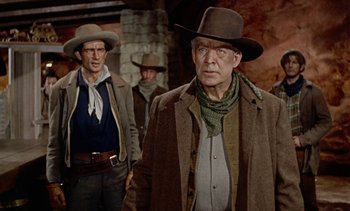 Movie still from “Johnny Guitar” (1954), directed by Nicholas Ray – A man wearing a cowboy hat standing next to another man wearing a cowboy hat; Medium shot, Low angle