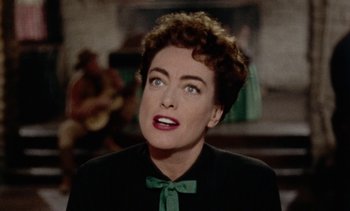 Movie still from “Johnny Guitar” (1954), directed by Nicholas Ray – An old photo of a woman in a black shirt and green bow tie; Close Up shot, Over the shoulder angle