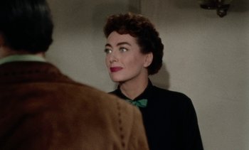 Movie still from “Johnny Guitar” (1954), directed by Nicholas Ray – An older woman looking at the camera in front of a mirror; Close Up shot, Over the shoulder angle