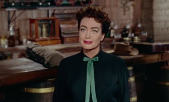 Movie still from “Johnny Guitar” (1954), directed by Nicholas Ray – A person wearing a suit and tie; Medium shot, Over the shoulder angle