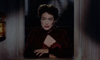 Movie still from “Johnny Guitar” (1954), directed by Nicholas Ray – A person sitting in a room; Close Up shot, Over the shoulder angle