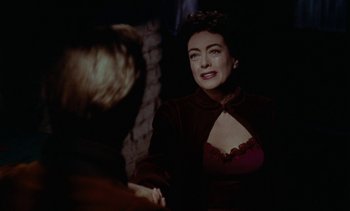 Movie still from “Johnny Guitar” (1954), directed by Nicholas Ray – A woman sitting in front of a man in front of a wall; Close Up shot, Over the shoulder angle