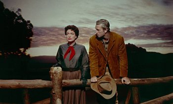 Movie still from “Johnny Guitar” (1954), directed by Nicholas Ray – A man and a woman standing next to each other on top of a wooden fence; Medium shot, Low angle