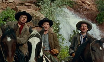Movie still from “Johnny Guitar” (1954), directed by Nicholas Ray – A group of men on horseback in front of a waterfall; Medium shot, Low angle