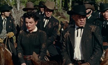 Movie still from “Johnny Guitar” (1954), directed by Nicholas Ray – A group of men and women in suits and hats sitting on horses; Medium shot, Low angle