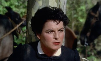 Movie still from “Johnny Guitar” (1954), directed by Nicholas Ray – A person wearing a suit near a tree; Close Up shot, High angle
