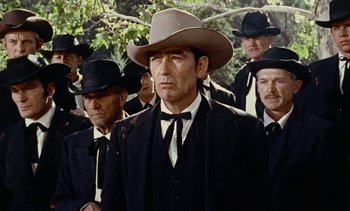 Movie still from “Johnny Guitar” (1954), directed by Nicholas Ray – A group of men wearing hats and suits; Medium shot, Low angle
