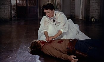 Movie still from “Johnny Guitar” (1954), directed by Nicholas Ray – A woman in a white dress and a man in a brown jacket; Medium shot, High angle