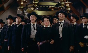 Movie still from “Johnny Guitar” (1954), directed by Nicholas Ray – A group of men and women standing in a room; Medium shot, Low angle