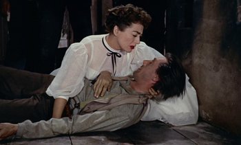 Movie still from “Johnny Guitar” (1954), directed by Nicholas Ray – A woman in a white blouse and a man in a brown jacket; Medium shot, Overhead angle