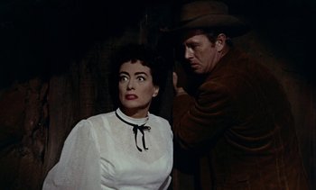 Movie still from “Johnny Guitar” (1954), directed by Nicholas Ray – A man and a woman are standing next to each other; Medium shot, Over the shoulder angle
